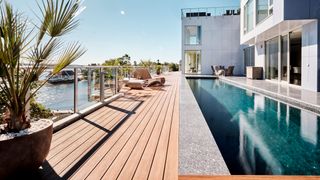 large swimming pool outside house with decking