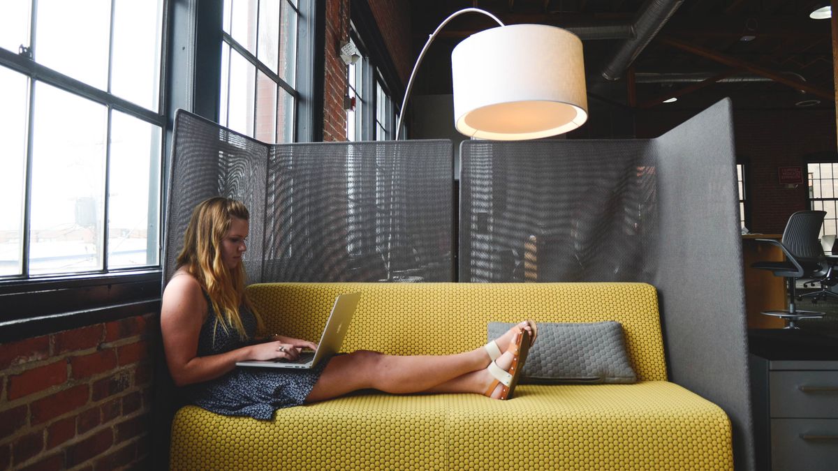 Woman Using Laptop on Couch