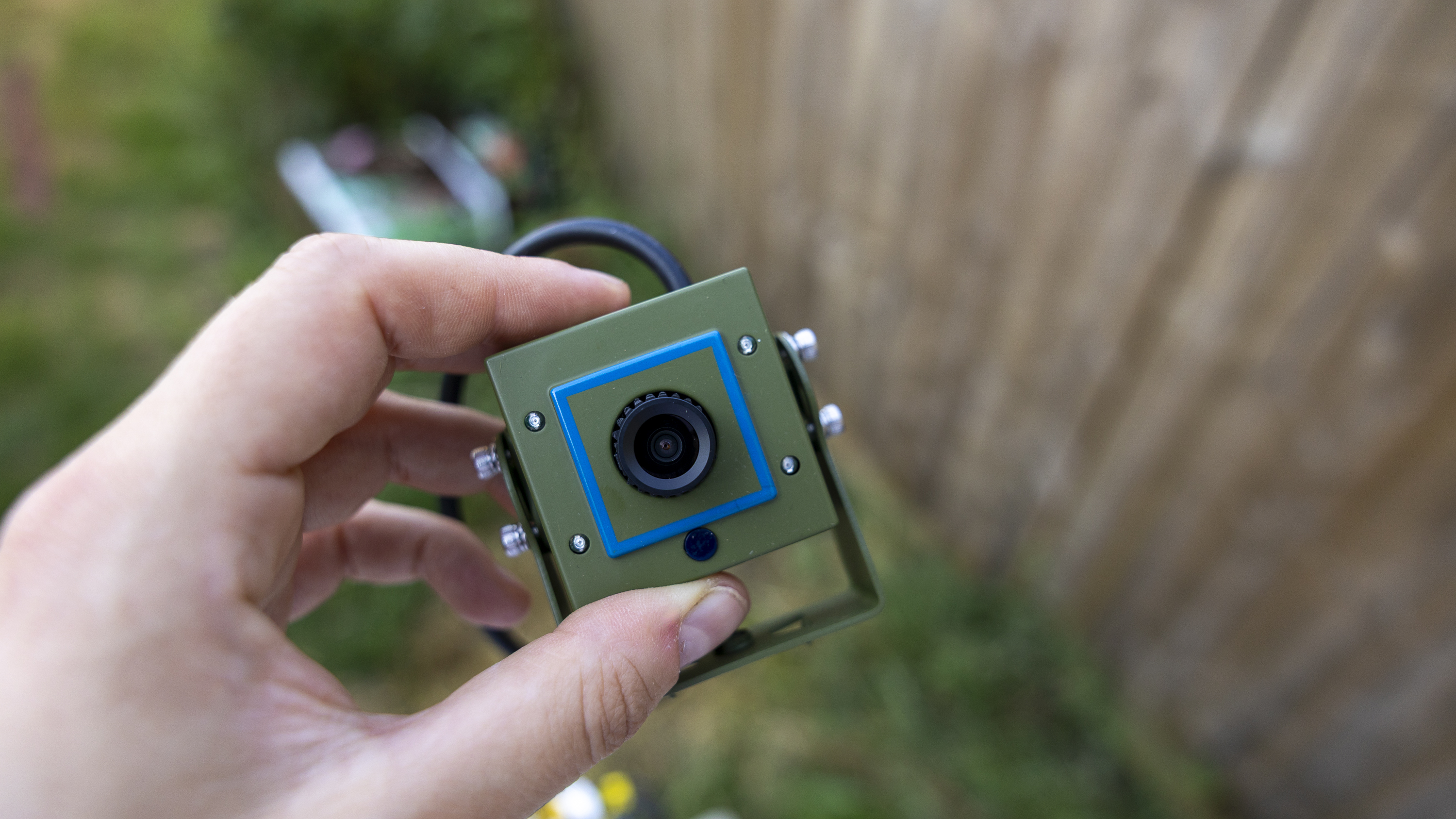 A female hand holding the Green Feathers bird box camera