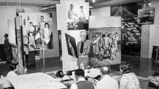 Photographer Edward Steichen (standing, center), director of photography at New York's Museum of Modern Art, assembles some of the photographs to be included in the Family of Man exhibition at the museum. The exhibition includes 500 photographs by more than 280 photographers in 68 countries. New York, January 25, 1955.