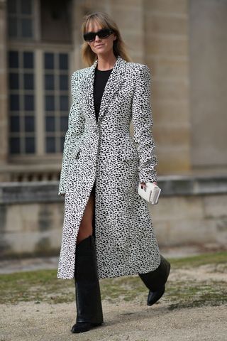A woman wearing a statement coat and knee high boots