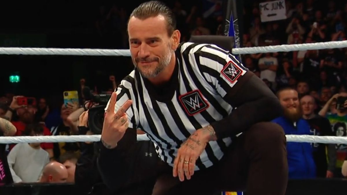 CM Punk holding up two fingers to Drew McIntyre with a smirk on his face. 