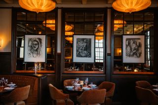 Three artworks and glowing ceiling lamps at Locanda Verde Hudson Yards