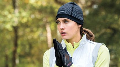 best running gloves: woman wearing running hat and running gloves