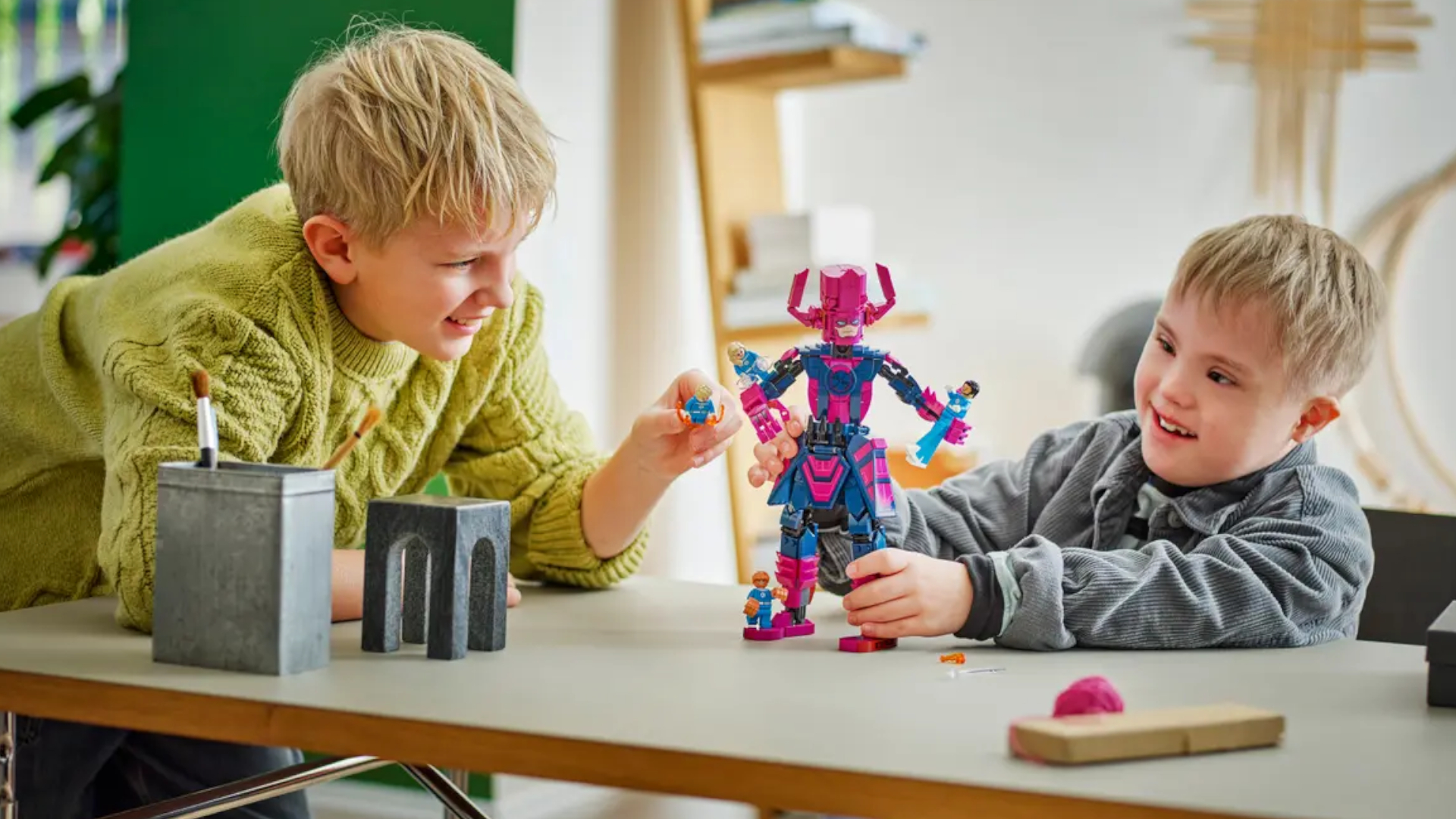 Two children play with the Lego Fantastic Four vs. Galactus set on a table