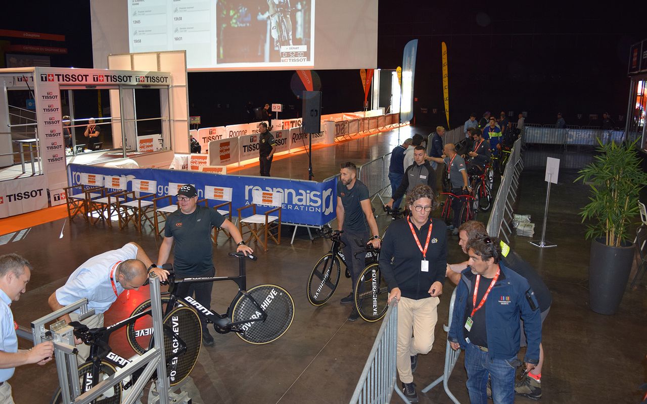 Team mechanics queue in the concert hall, which hosted the stage start, to ensure each rider's bike was UCI compliant ahead of the stage