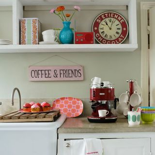 kitchen room with wooden wall mounted shelves and coffee maker machine