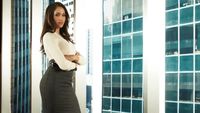 Rachel Zane (Meghan Markle) poses by a window for a Suits season 1 photocall
