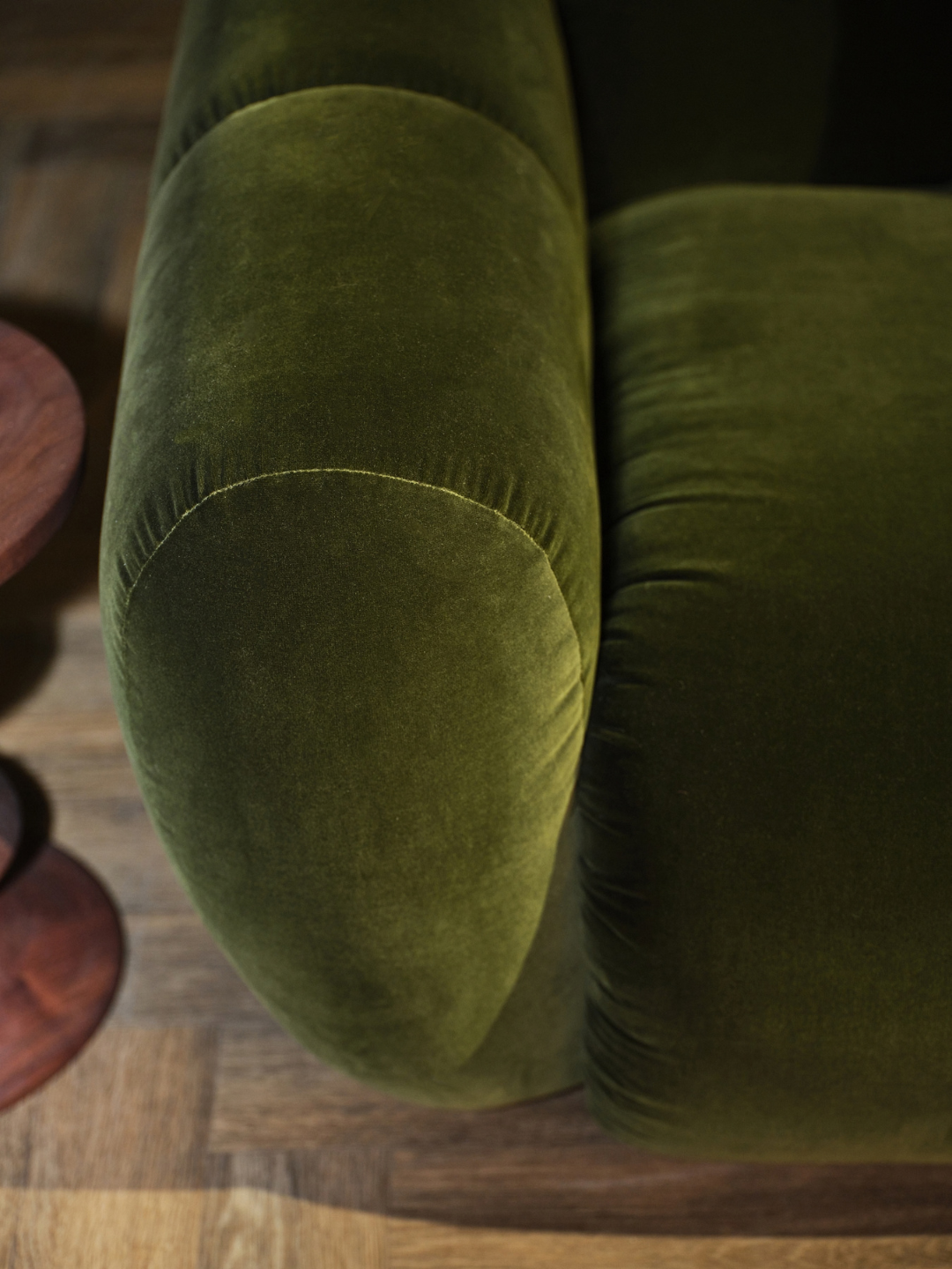 Close-up of the Cavo modular sofa, showing its softly rounded arm and clean seam detailing in Cotton Velvet Evergreen.