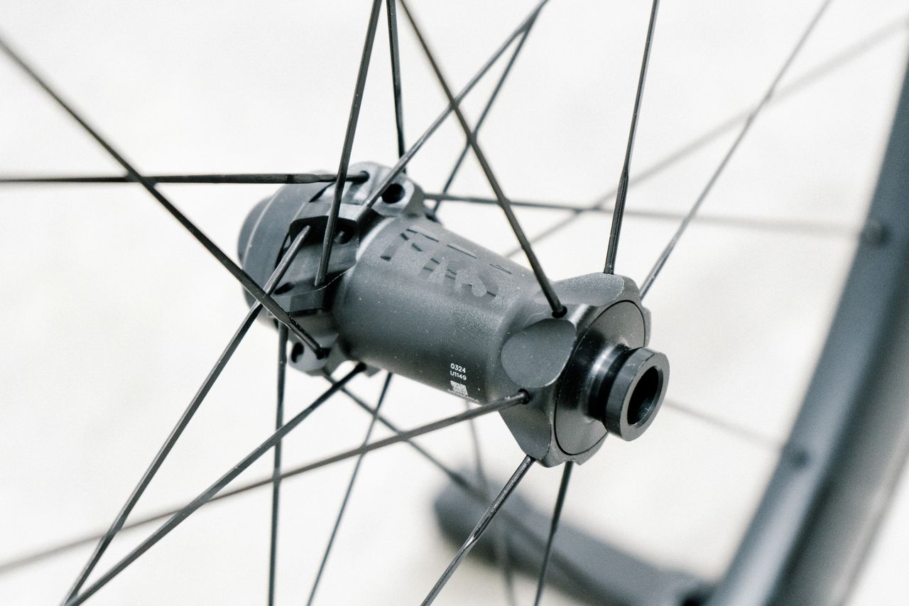 An aero road wheel stands against a white wall