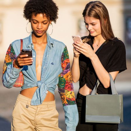 Two women looking down at their mobile phone screens