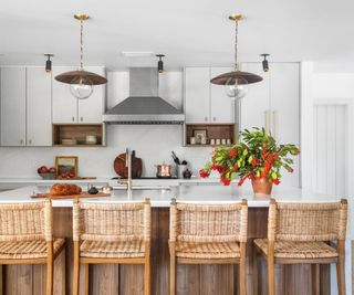 kitchen with flat white cabinets basket bar stools statement lights