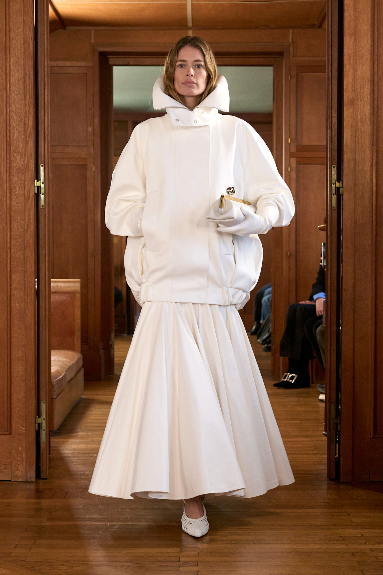 Jacquemus model carrying a kisslock clutch bag on the spring/summer 2025 runway