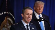 Gen. Dan Caine speaks with President Donald Trump in the background