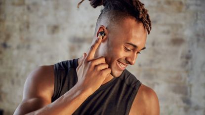 Best running headphones: Pictured here, a handsome your man wearing the LG TONE Free fit UTF8 headphones