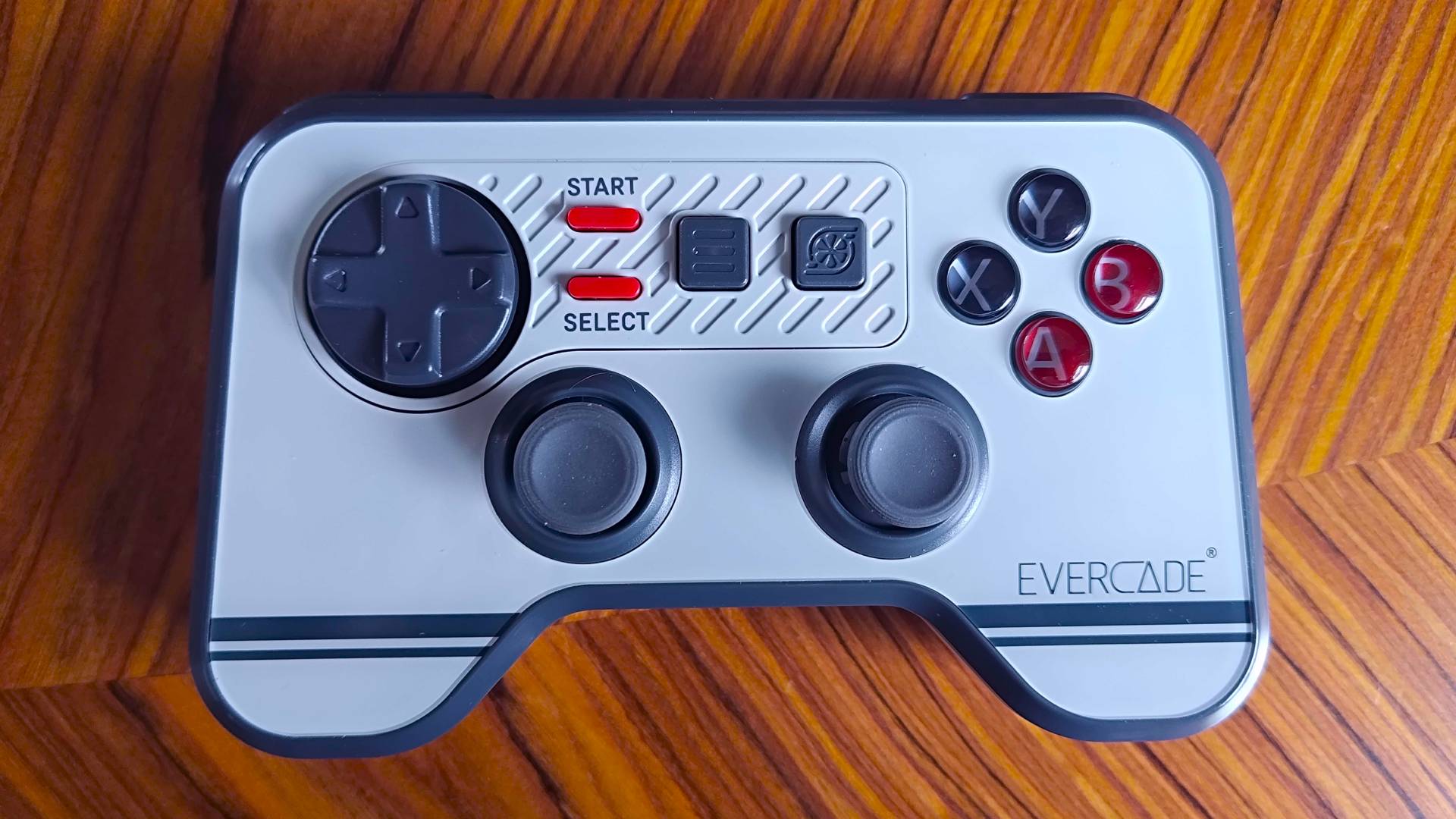 Face down view of Evercade Dual Thumbstick Wireless controller on woodgrain desk.