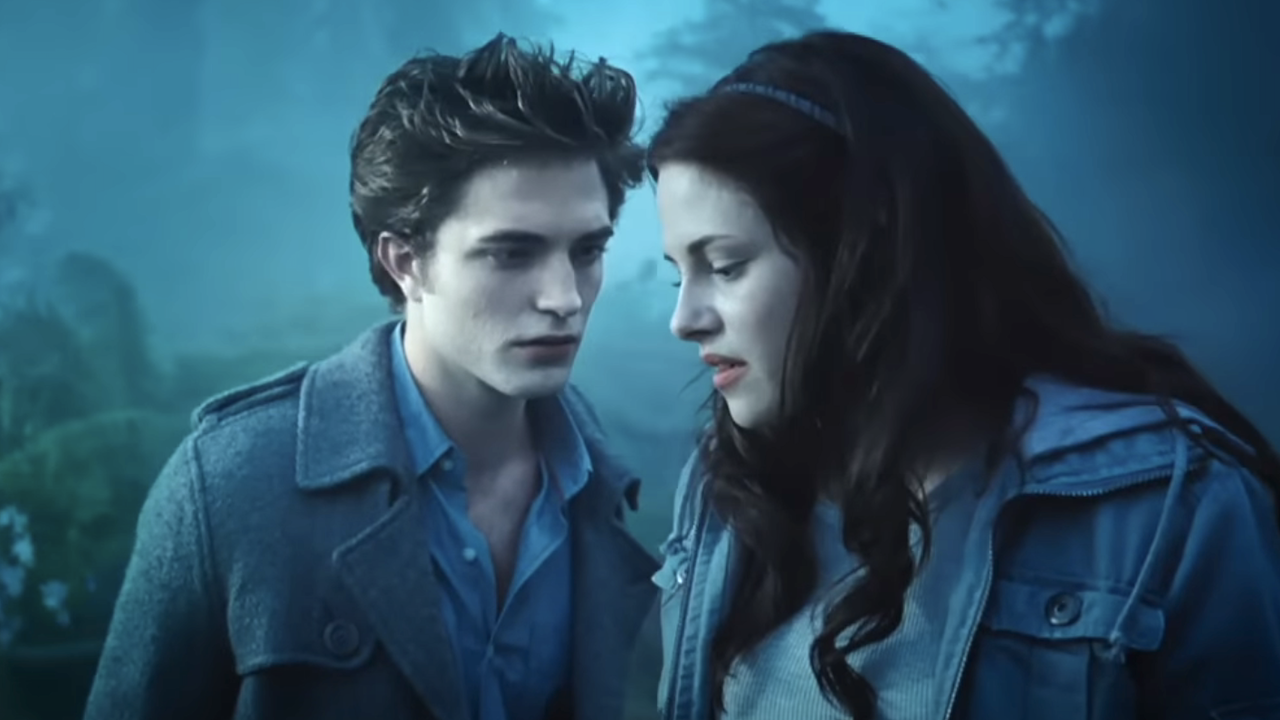 Robert Pattinson and Kristen Stewart facing each other in a forest in Twilight 
