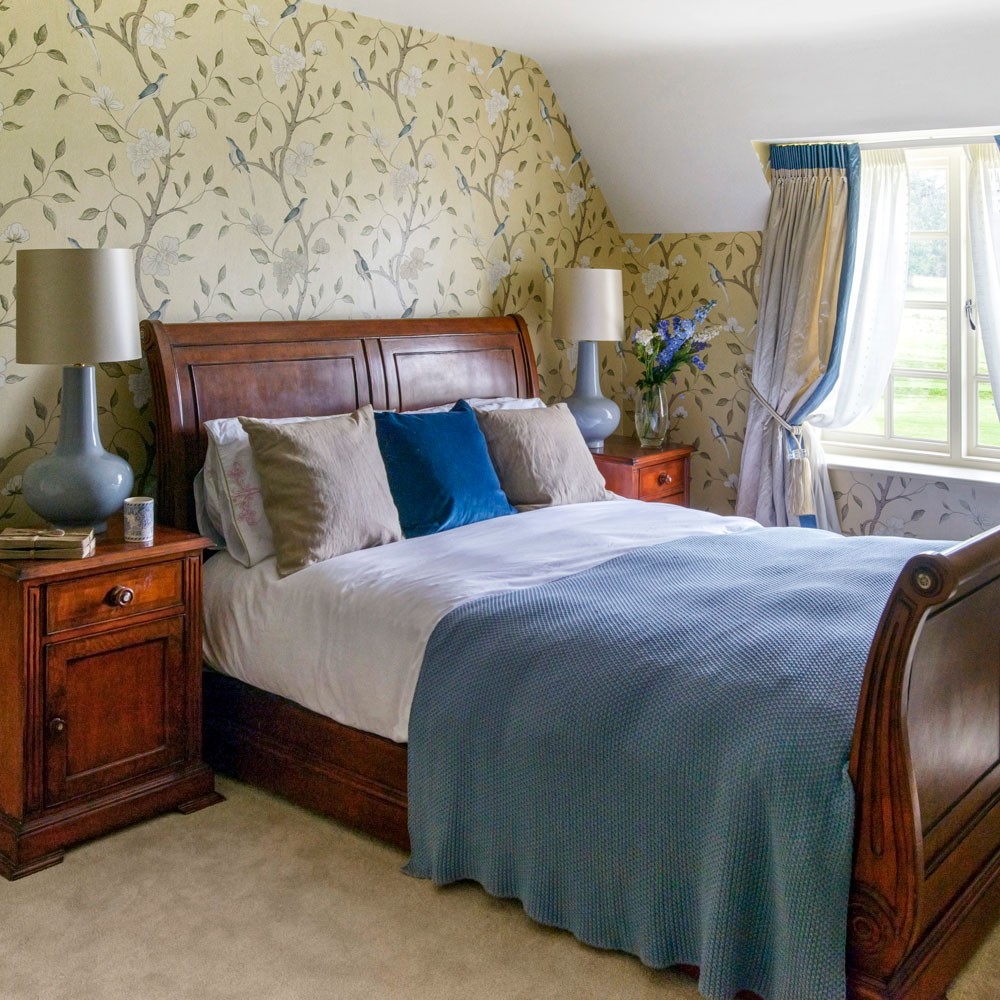 bedroom with wallpaper and lamps