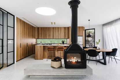 A fireplace in the middle of an open plan