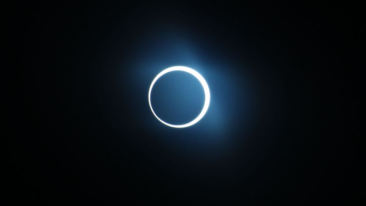 The moon is photographed haloed by the sun in a black sky during an annular solar eclipse.