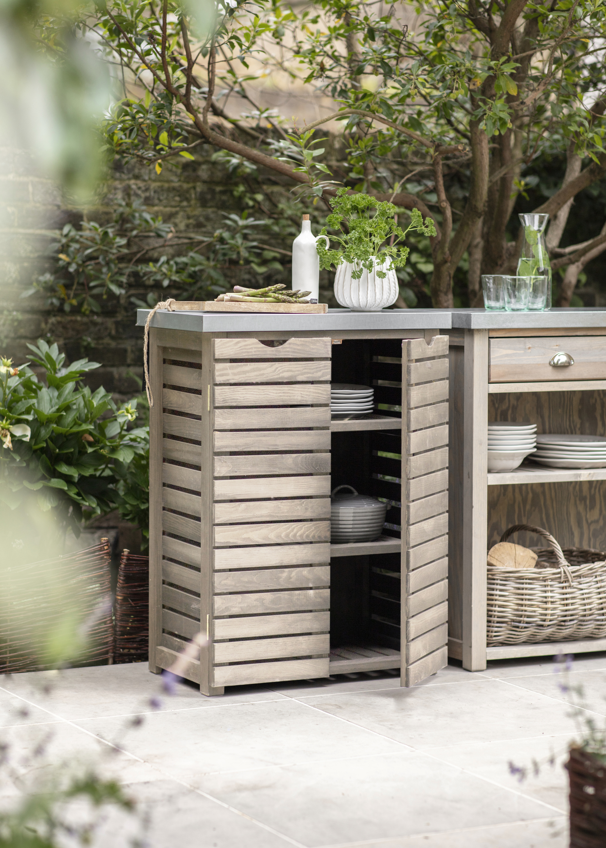 An outdoor kitchen area with a wooden cabinet for storage
