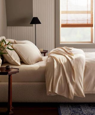 Side view of Brooklinen Heathered Cashmere Sheets against a cream wall.