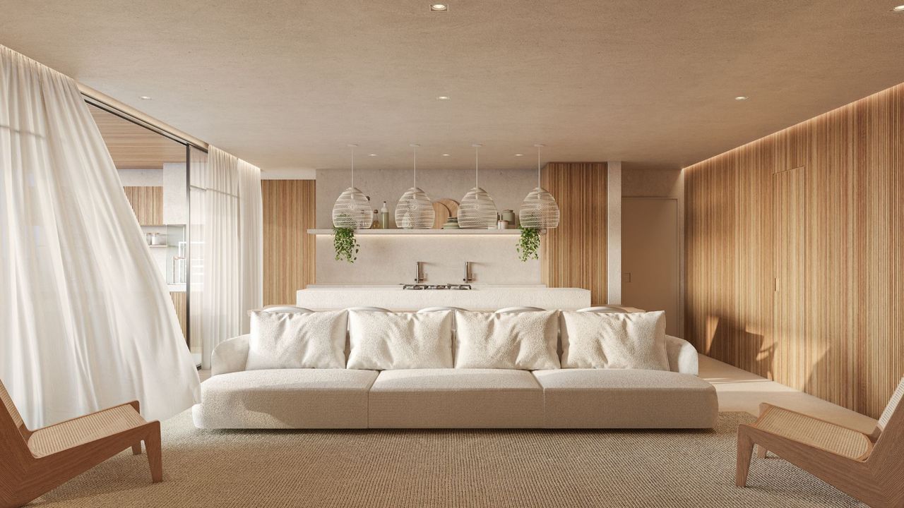 A living room with a white sofa and wooden accent chairs 