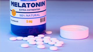 bottle of melatonin tablets with pills on a table