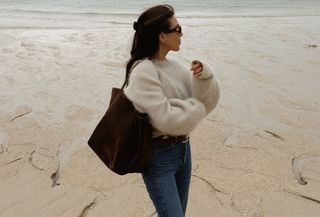 Woman in cozy sweater and jeans.