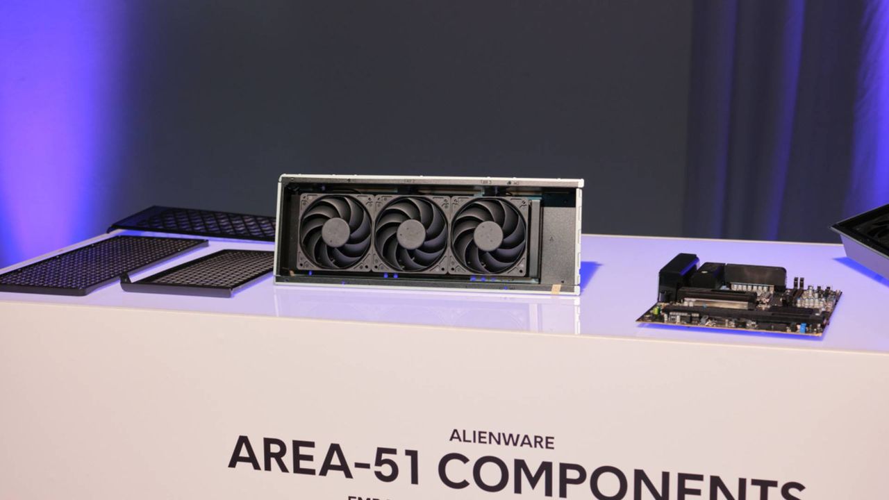 Alienware Area 51 components sitting on white surface including AIO cooler fans and motherboard