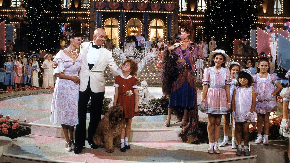 Albert Finney, Aileen Quinn, Carol Burnett and others on stage in a scene from the 1982 film &#039;Annie&#039;.