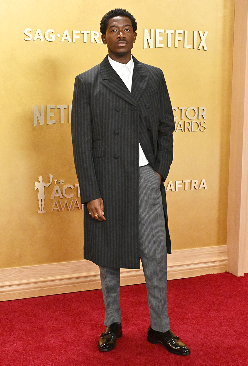 Damson wears a stripe jacket and pants