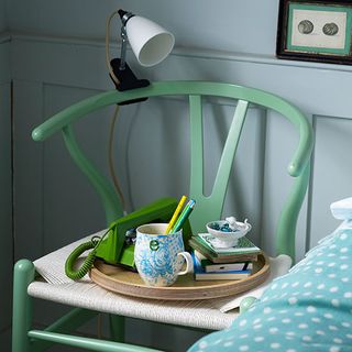 green chair with lamp mounted cup and book