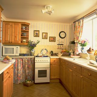 kitchen room with wooden flooring and wooden kitchen cabinets