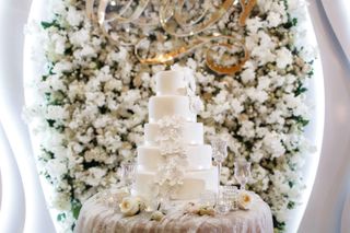 white flower wall ideas behind wedding cake