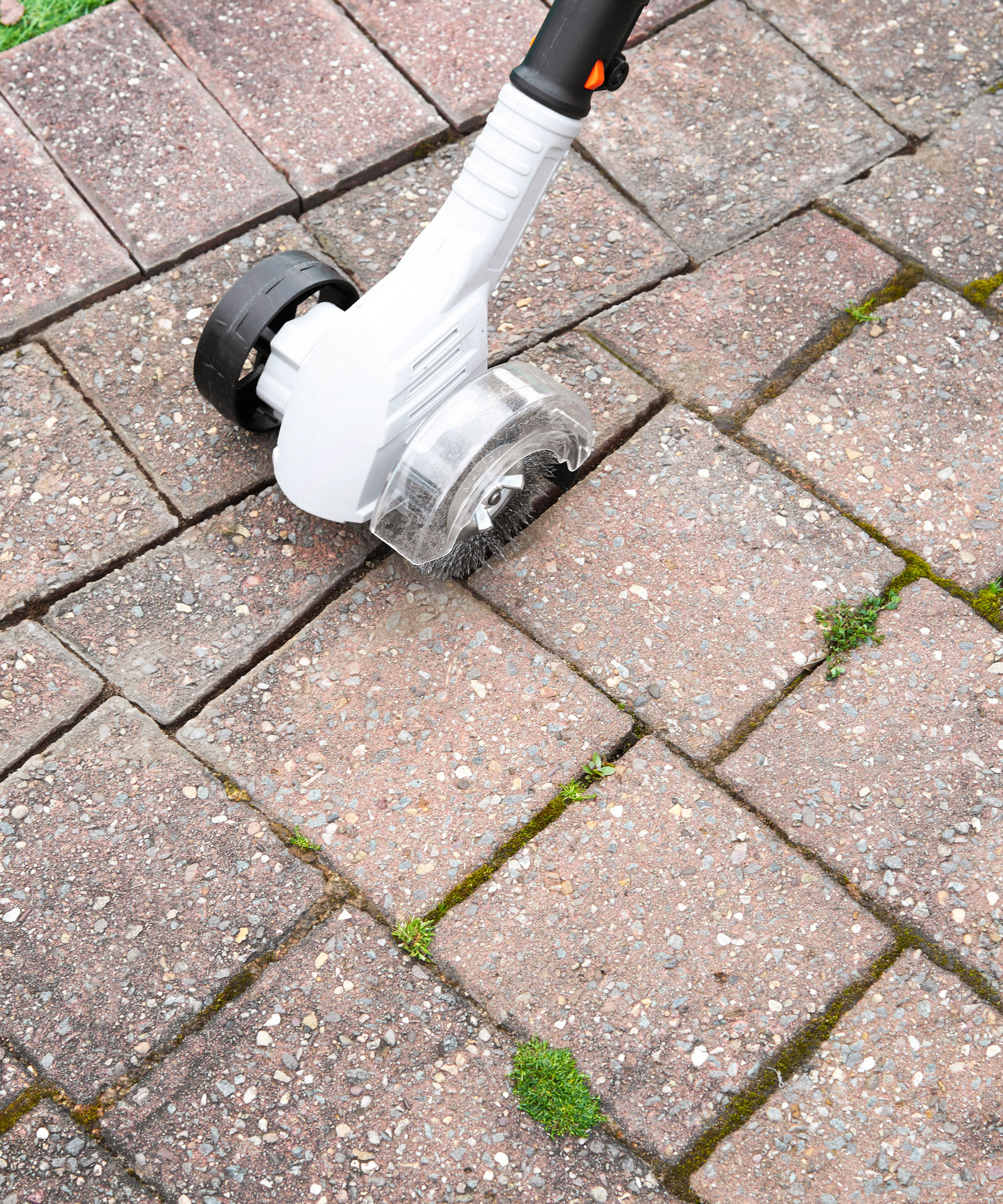 electric weed removal tool getting weeds out of cracks in paving