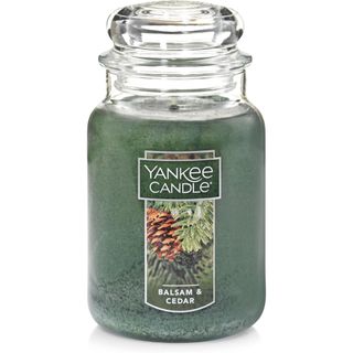 A glass Balsam & Cedar Yankee Candle with green wax