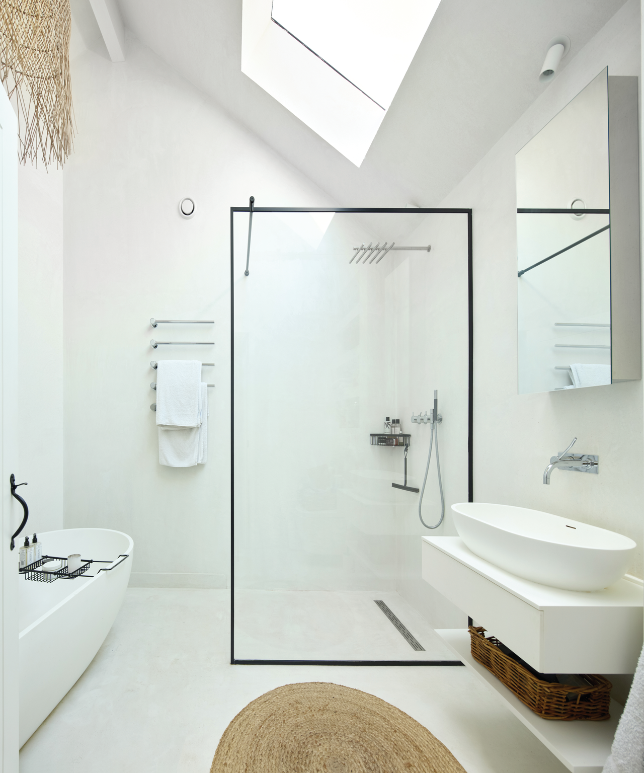 White bathroom with skylight above the shower and black rim shower screen