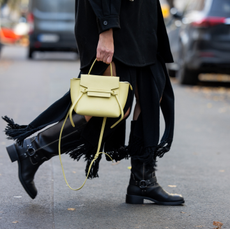  Victoria Scheu wears black fringe dress Cos, jacket &other stories, sunnies off white, yellow Celine bag, white beanie, sweater, black boots, sunglasses on November 27, 2023 in Berlin, Germany
