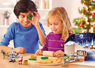 An image of two children playing with items from the Playmobil Christmas Baking Advent Calendar