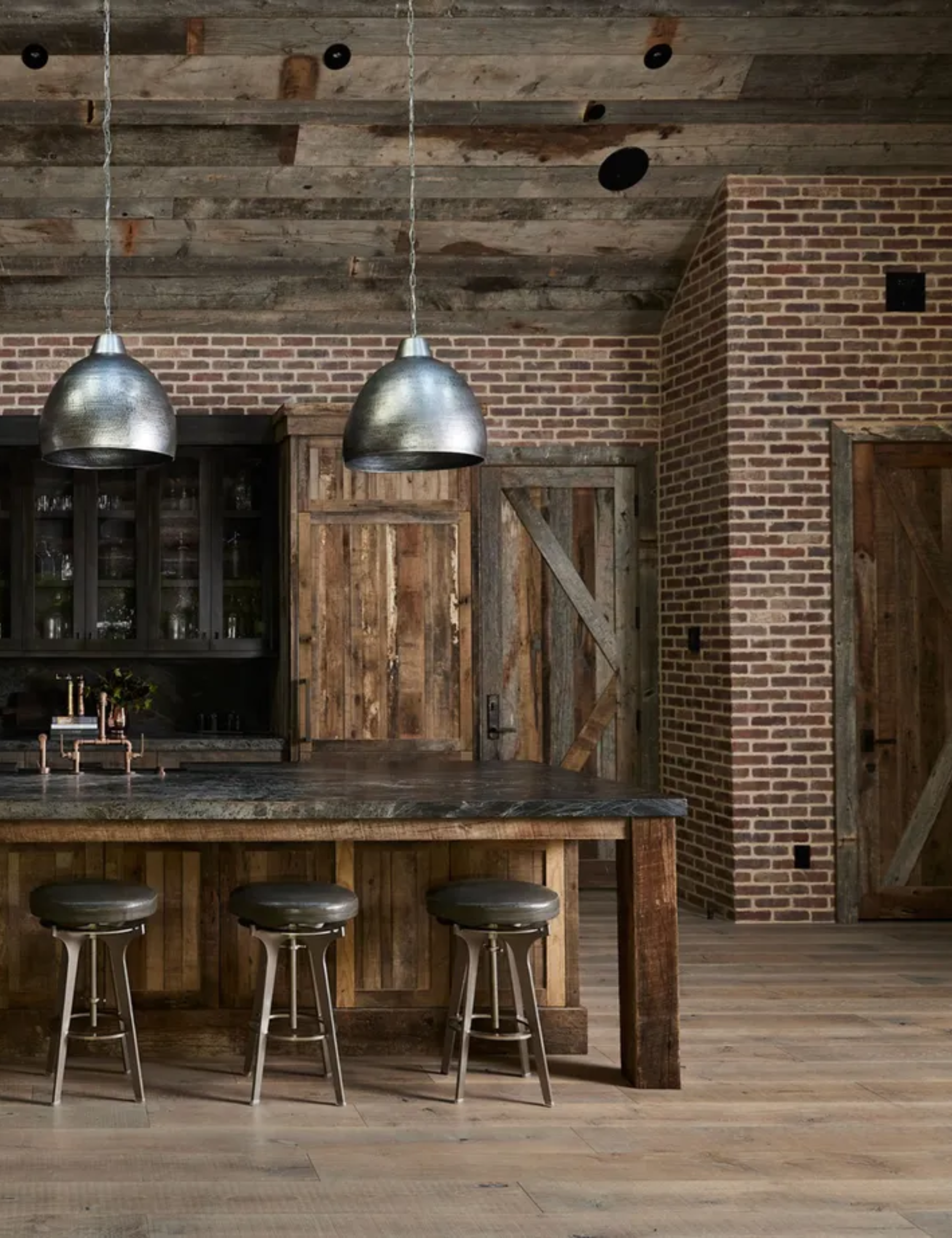 An industrial kitchen with brick walls and a wooden ceiling