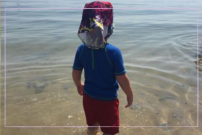 Little boy in swimming outfit looking out to see