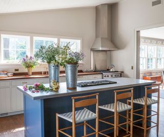 kitchen with blue island and wooden bar stools