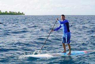 Steve Backshall standing on a paddleboard in the Maldives