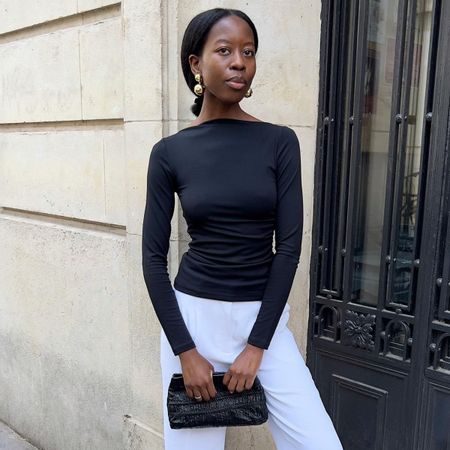 Woman in black top and white pants