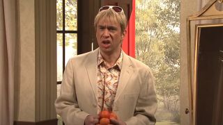 Fred Armisen as his character in the Californians' sketch holding tangerines.