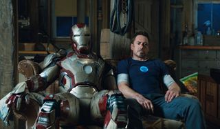 Iron Man 3 Tony sitting on a couch, next to his armor