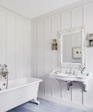 White bathroom with wood paneling and roll top bath