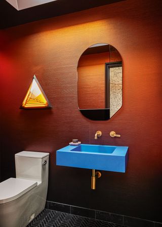 The bathroom in this San Francisco renovation, featuring angular details and a blue accent sink