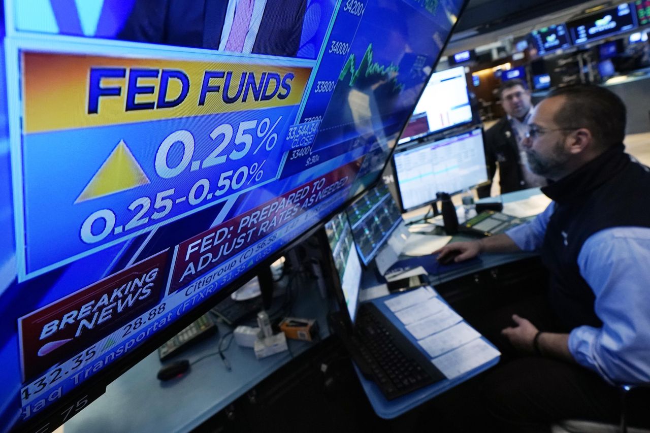 A New York Stock Exchange TV displays the Fed&amp;#039;s quarter-point hike